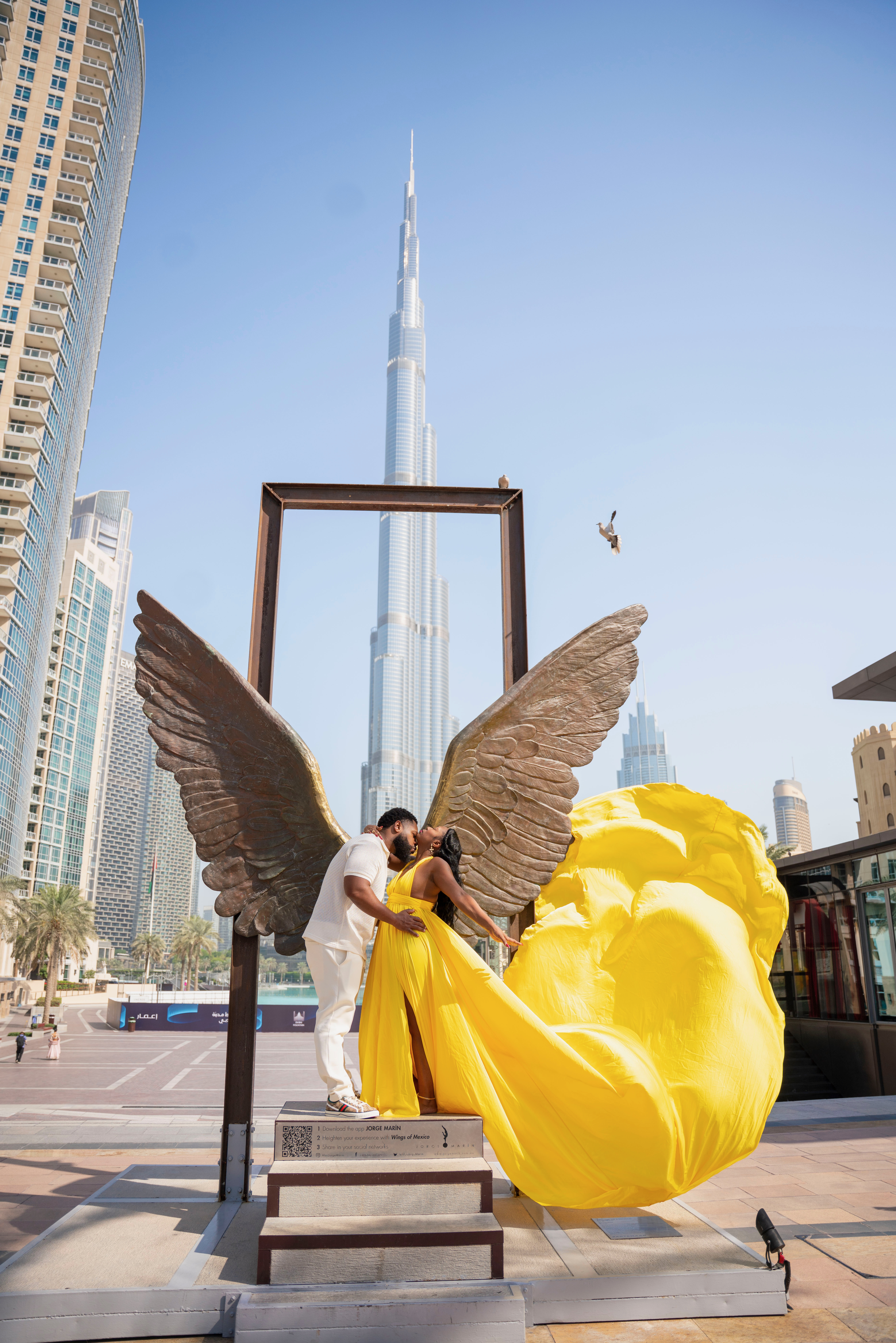 The Newkirks in Dubai beside a sweeping yellow gown and the Burj Khalifa