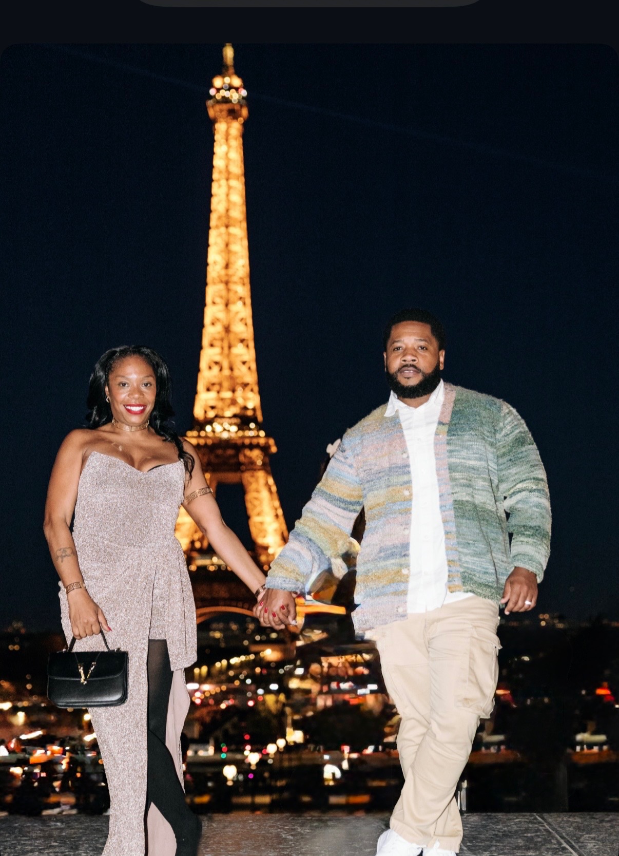 The Newkirks holding hands in front of the Eiffel Tower five years later